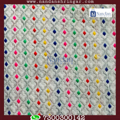 White designer zari vastra by nandanshringars, showcasing intricate embroidery and elegant fabric draping.