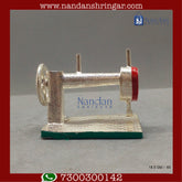 Fine silver Utsav Arts sewing machine with various stitching options displayed on a clean workspace.