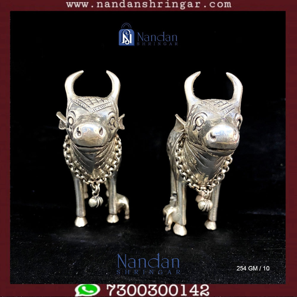 Fine silver cow figurines, Utsav Arts, showcase intricate details and craftsmanship in a pair of elegant designs.