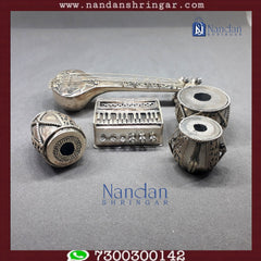 Fine silver musical set by Utsav Arts featuring intricate designs and traditional instruments displayed elegantly.