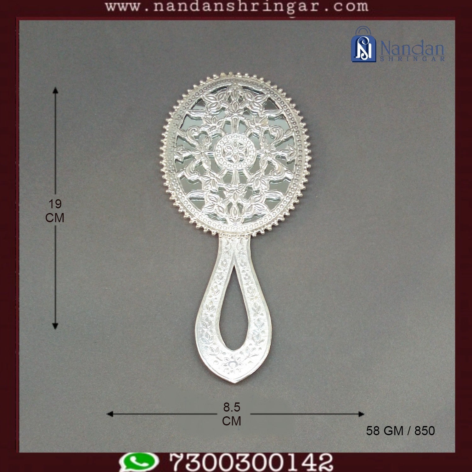Fine silver Aarsi mirror by Utsav Arts, featuring intricate detailing and a reflective surface, displayed on a decorative stand.