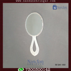 Fine silver Aarsi mirror from Utsav Arts showcasing intricate designs and a reflective surface.