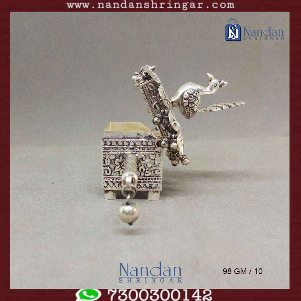 Fine silver Mayur Doli Box by Utsav Arts, featuring intricate designs and a polished surface, displayed elegantly.